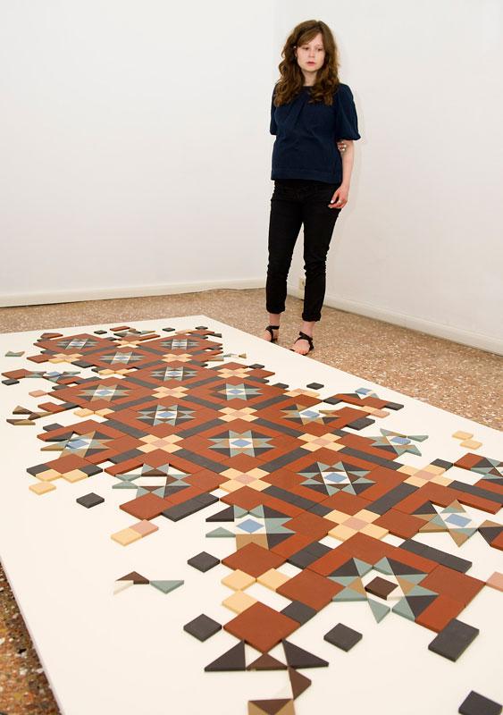 Corin Sworn in front of <em>Untitled</em> (2013), a ceramic-tile work, at Palazzo Pisani (S.Marina) / Photo Marco Secchi/Getty images for “Scotland + Venice” © 2013 Getty Images