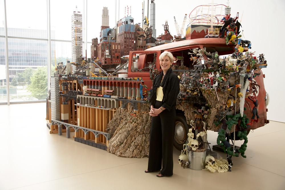 Art Gallery of Hamilton CEO and president Louise Dompierre with Kim Adams's <em>Bruegel-Bosch Bus</em>, a centrepiece of the gallery's collection / photo Mike Lalich