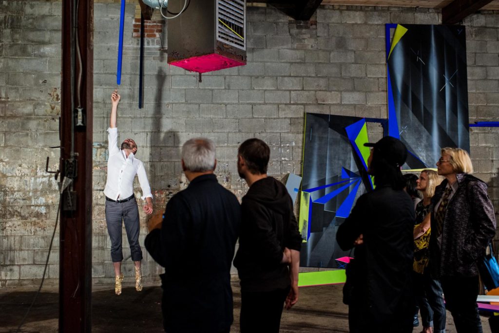 Gallery Hoppers enjoy a performance piece by artist Francisco-Fernando Grenados. Pictured with work by Janet Jones at Katzman Contemporary. Photo Emma McIntyre.