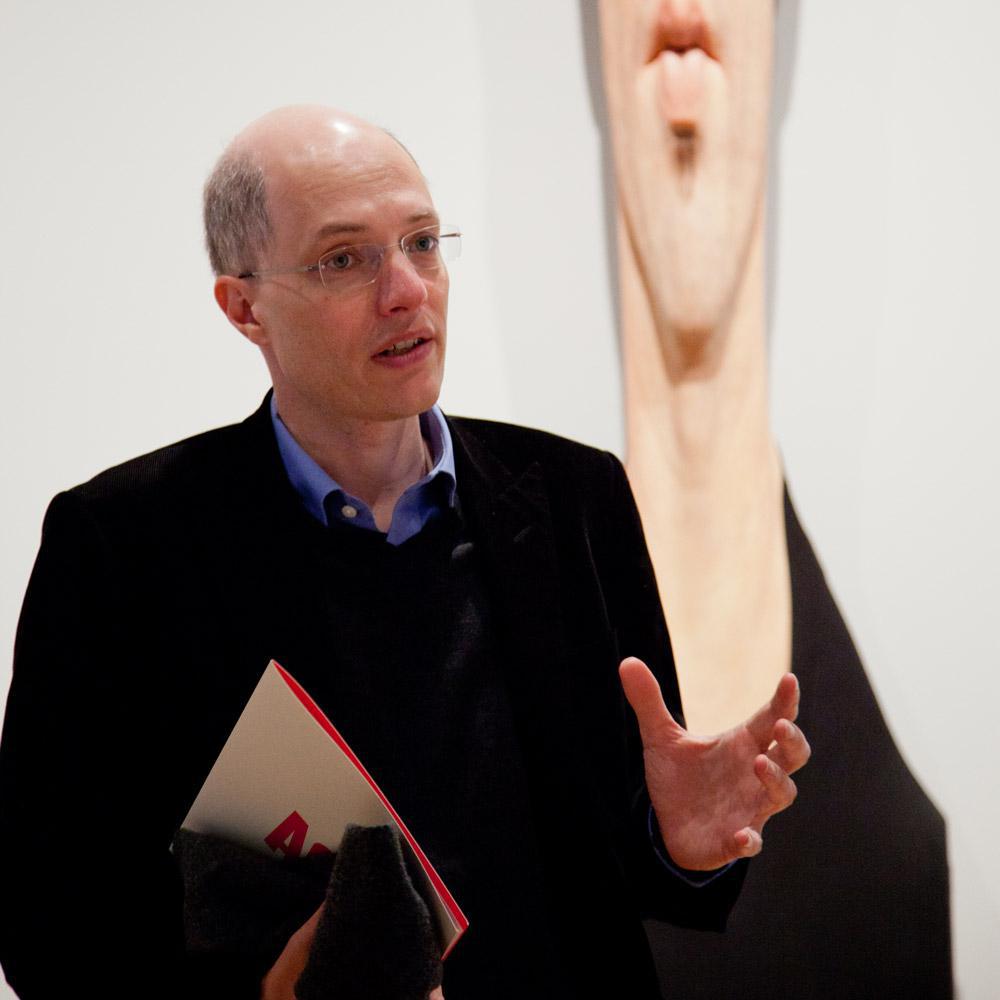 Alain de Botton speaking in front of an Evan Penny sculpture in the AGO's “Art as Therapy” exhibition.