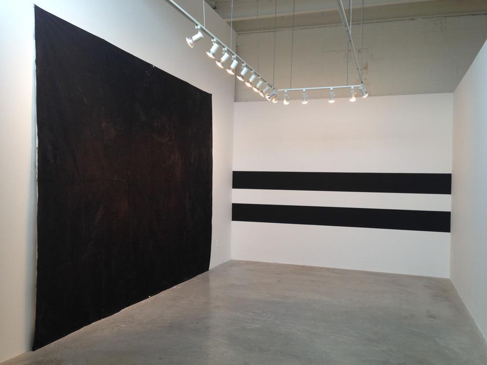 Left: Nicole Ondre, <em>The Pliable Plane</em>, 2014. Tyvek, thread, oil paint, asphalt. Right: Neil Campbell, <em>Plumb (shoreline)</em>, 2014. Acrylic on wall. Installation view at Diaz Contemporary.