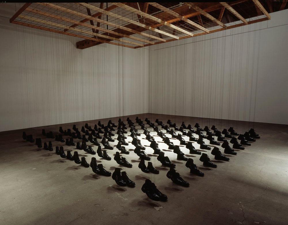 Dominique Blain, <em>Missa</em>, 1997.  100 pairs of army boots, nylon threads, metal grid and wood, 600 x 600 x 300 cm. Collection Montreal Museum of Fine Arts. Image courtesy Galerie Antoine Ertaskiran.