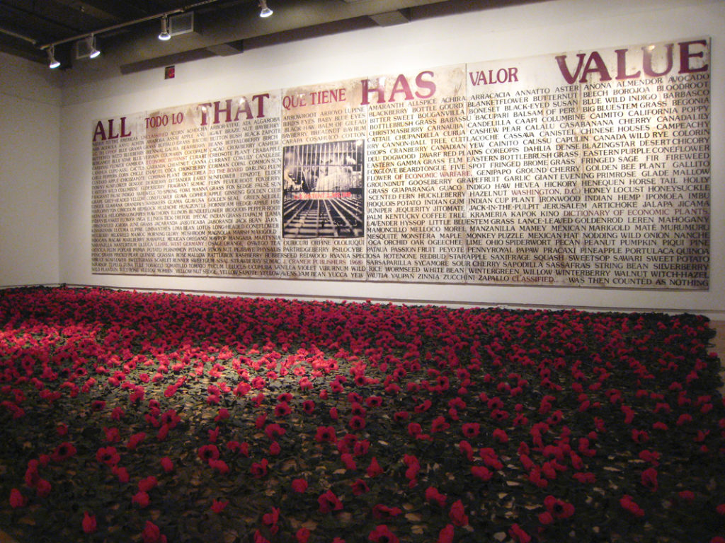 Ron Benner's <em>All That Has Value</em> (1993–2014) (on wall) with Jamelie Hassan's <em>Poppy Cover (for Holy Roller)</em> (2010) (on floor). Photo courtesy A Space Gallery.