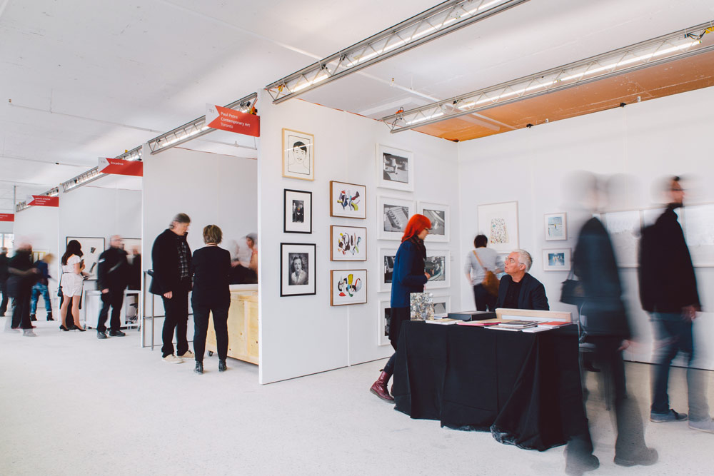 Visitors at Papier15 take in various types of works on paper. In the foreground is the booth of Paul Petro Contemporary Art. Photo: Jean-Michael Seminaro.