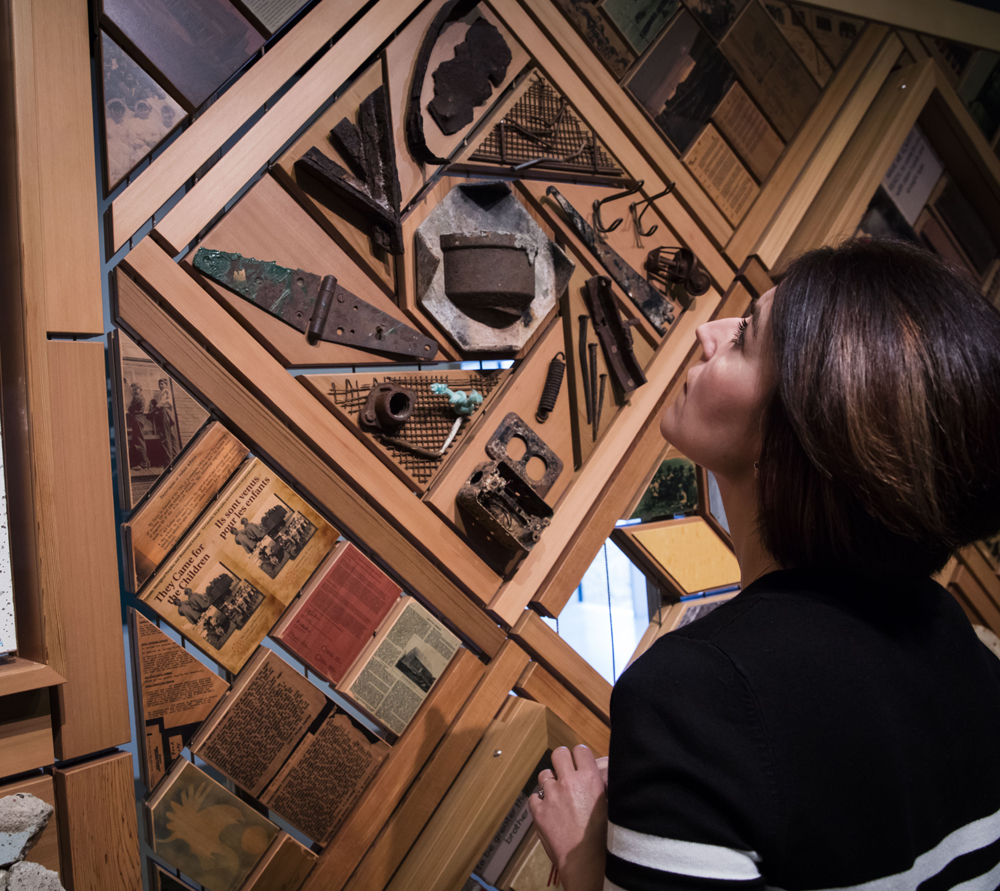 A viewer looks at some of the 800+ objects that make up <em>The Witness Blanket</em>, including remnants from residential schools and related institutions like churches and government buildings. Photo: Canadian Museum for Human Rights.