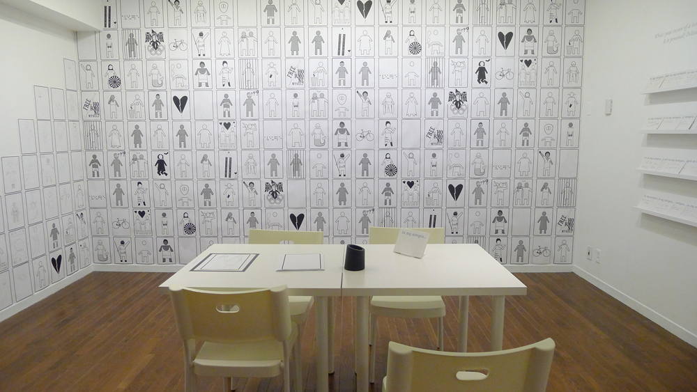 Installation view of Coco Guzman’s <em>Genderpoo</em> (2008–ongoing) at the Textile Museum of Canada as a part of “Eutopia” in 2016. <em>Genderpoo</em> offers myriad reimaginings of binary-gender washroom signage. Photo: Paul Henderson.
