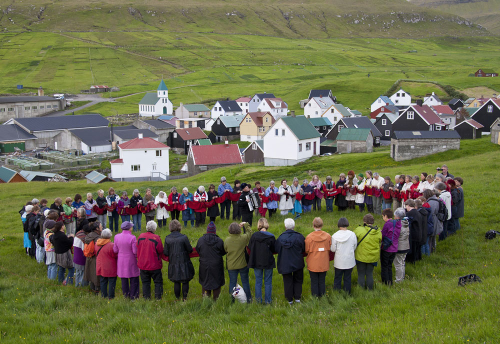 Dozens of people knit simultaneously for one hour in the art piece Own Our Own Time by Swedish artist Kerstin Lindstrom. Pictured here in a Faroe Islands event, the piece will have its North American premiere in Quebec on August 27. Photo: La Triennale Internationale des Arts Textiles en Outaouais.
