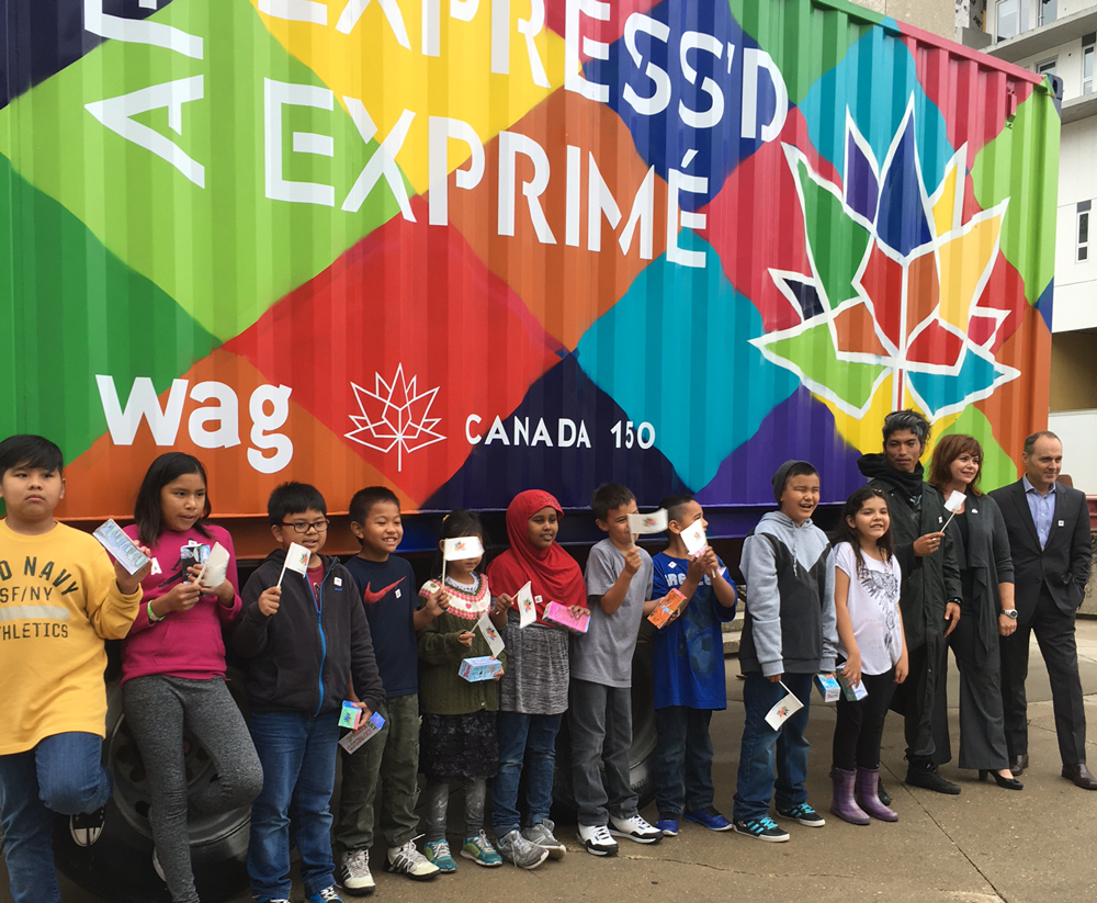 Grade 4 students from Sister MacNamara Elementary School helped celebrate the launch of Art Express'd. They are pictured here along with artist Nereo II (who painted the container), Brigitte Gibson, regional director general, Prairies and Northern Region, and Stephen Borys, director and CEO, Winnipeg Art Gallery. Photo: Leif Norman.