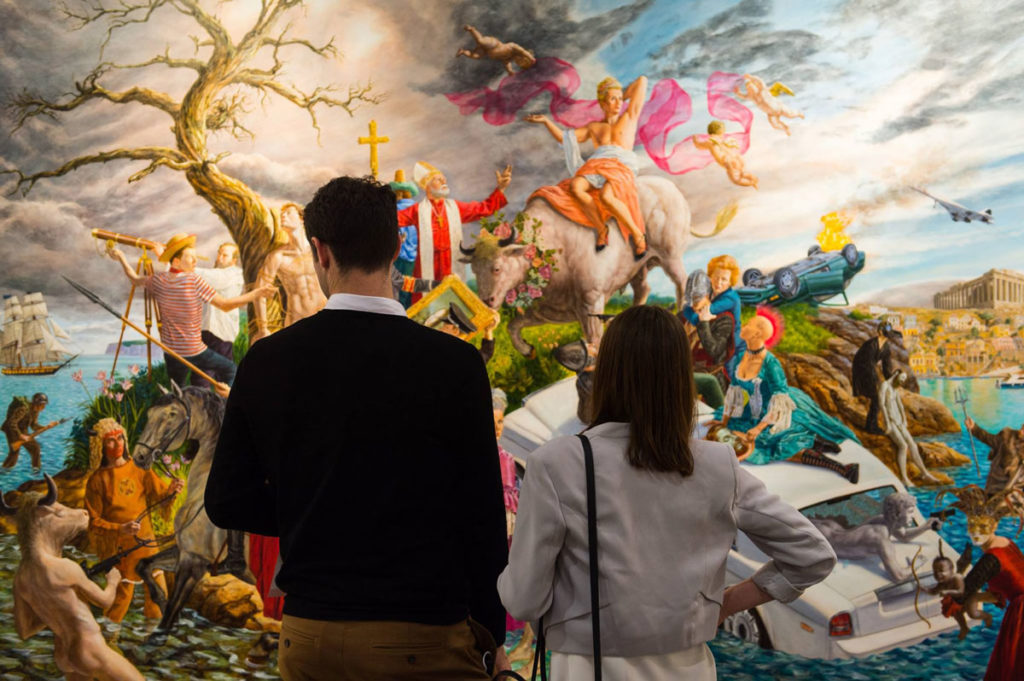 Two visitors to Art Toronto consider Kent Monkman's <em>Miss Europe</em>, a large painting completed a week before the fair and sold on opening night by Pierre-François Ouellette art contemporain of Montreal. Photo: via Art Toronto Facebook page.