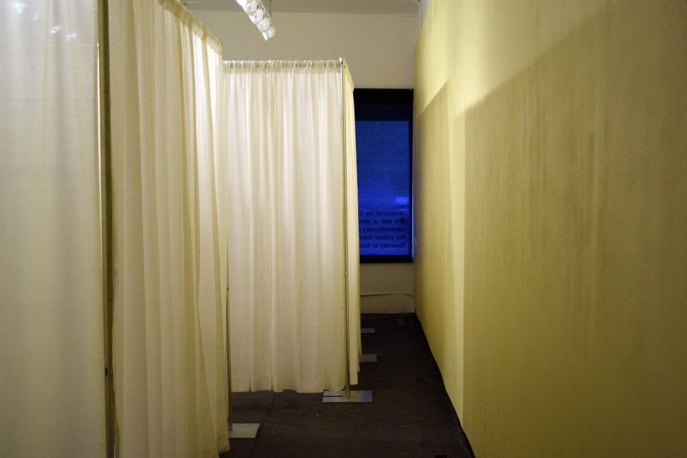 A view of Sheena Hozsko's installation <em>Correctional Service Canada Accommodation Guidelines: Mental Healthcare Facility 10m2 x 2</em> at the New Gallery in Calgary. The installation, constructed out of rented pipe and drape,  is based on prison-design guidelines Hoszko obtained via an access to information request. Image courtesy the artist.