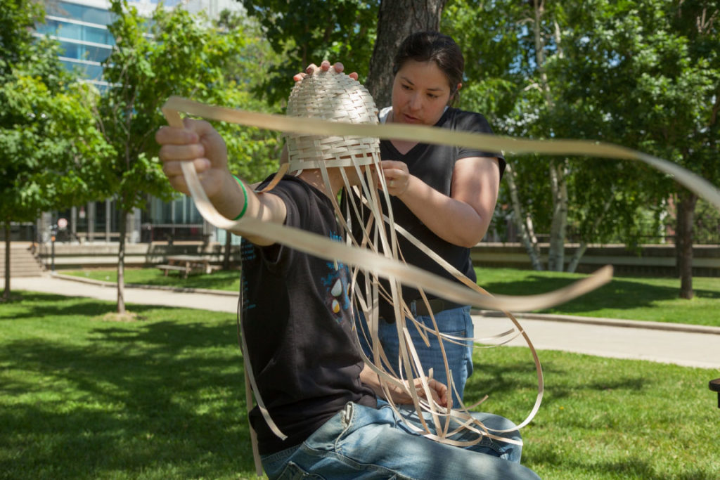 Mi'kmaw artist Ursula Johnson weaves traditional basketry around a volunteer's body in her 2014 performance <em>L’nuwelti’k (We Are Indian)</em>. Image courtesy of Carleton University Art Gallery for "Making Otherwise: Craft and Material Fluency in Contemporary Art," curated by Heather Anderson.
Photo: Justin Wonnacott.
