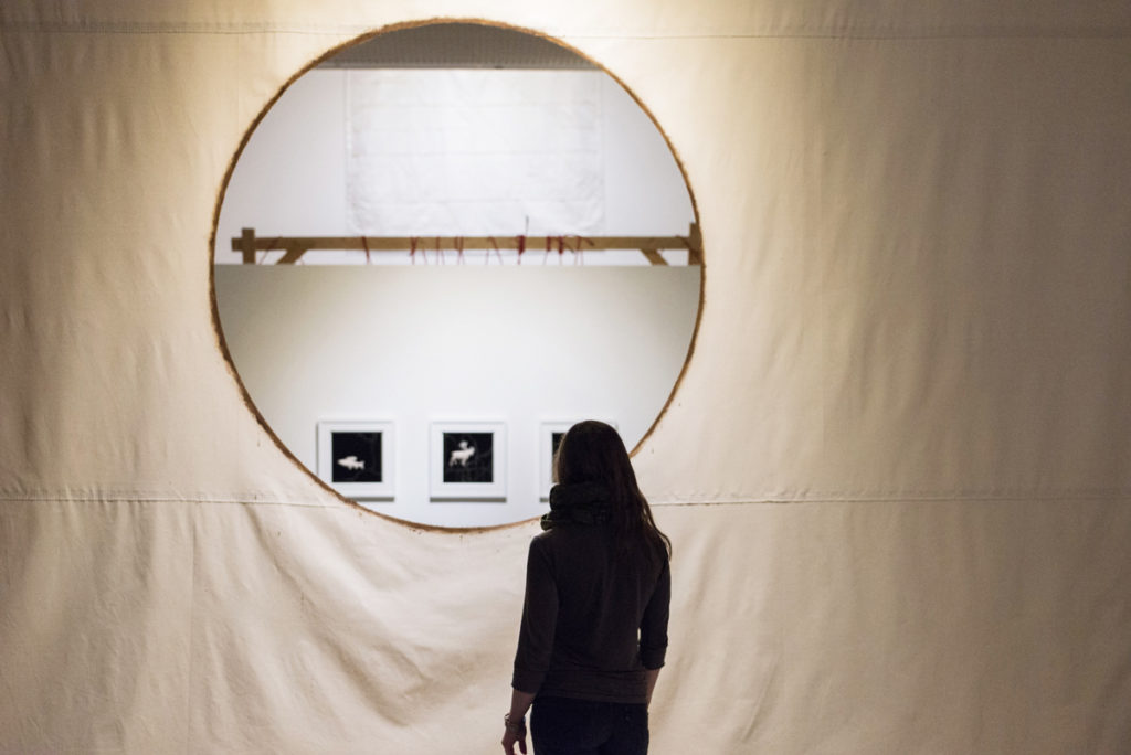 A visitor pauses at <em>Heart</em>, the work which forms both a portal and wall in relation to Amy Malbeuf’s exhibition “Tensions” at the Illingworth Kerr Gallery in Calgary. Photo: Chelsea Yang-Smith