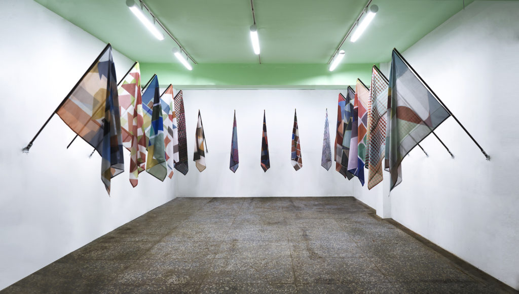 John Monteith, <em>Kindred Spirits</em> (installation view), 2018.
Dye sublimation prints on nylon, wood and brass, each flag 1.27 m x 93.9 cm x 1.52 m. Courtesy Division Gallery.
