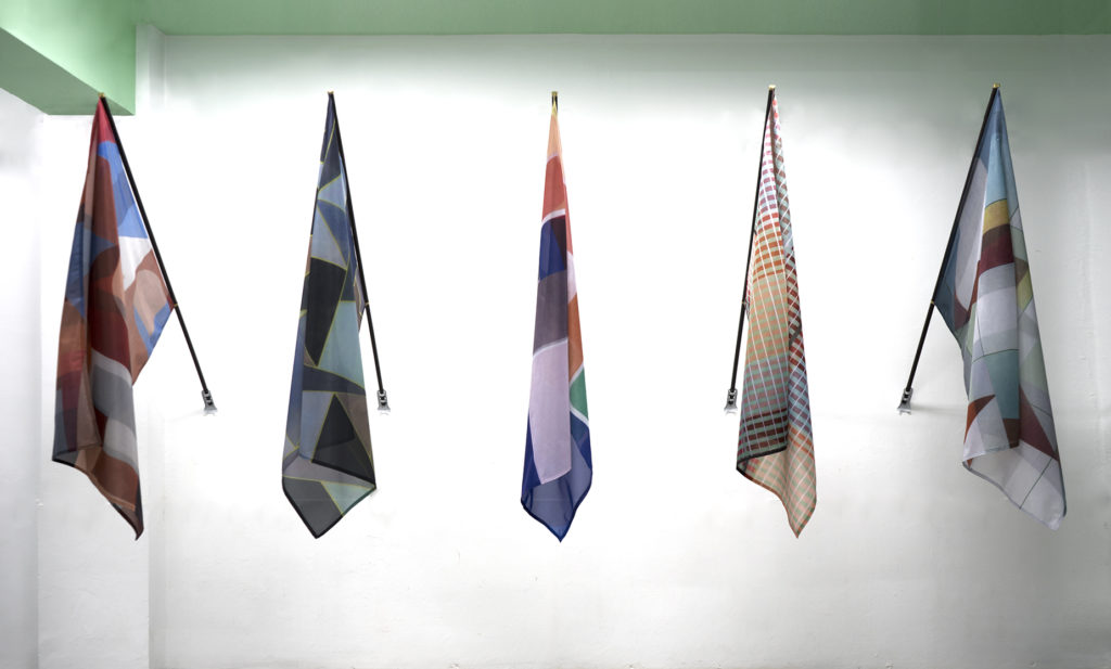 John Monteith, <em>Kindred Spirits</em> (installation view), 2018.
Dye sublimation prints on nylon, wood and brass, each flag 1.27 m x 93.9 cm x 1.52 m. Courtesy Division Gallery.
