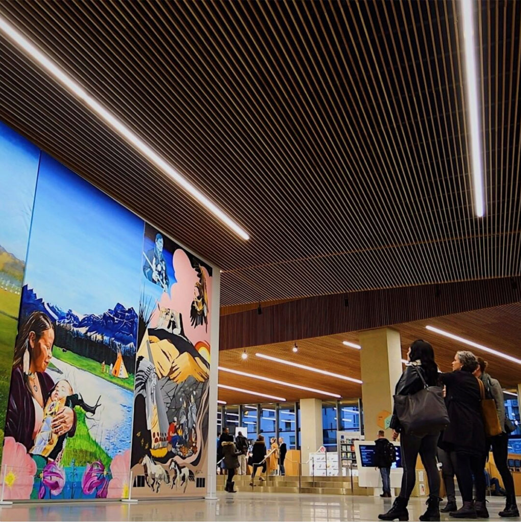 In the new central branch of the Calgary Public Library, a wall mural by Keegan Starlight, Kalum Teke Dan, and Roland Rollinmud greets visitors. Other works by Indigenous artists, and other exhibition and performance opportunities, are just one recent bright spot in the city's evolving art scene. Photo: Instagram / Calgary Public Library.