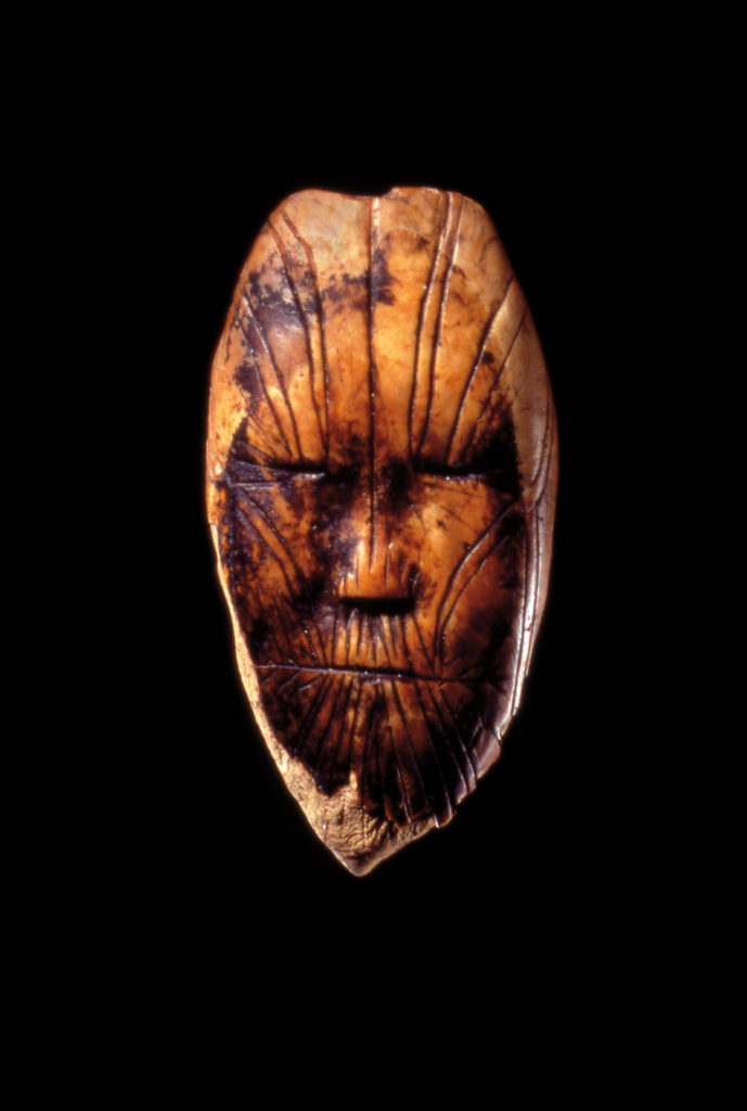 Maskette, Devon Island, Nunavut ca. 1900–1600 BC. Walrus ivory, 5.4 cm x 2.9 cm x 8 mm. Collection Canadian Museum of History. 
