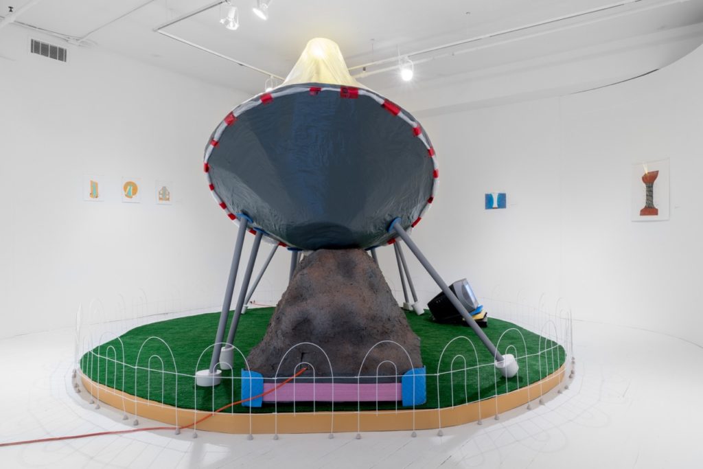 Sherry Walchuk, <em>Sun Tunnel Satellite Dishes</em> (installation view: behind the dish), 2016–19. Papier mâché, cardboard, wood, tape, plastic, acrylic paint, plaster, lights, astroturf, TV, DVD player, foam and electrical cords, 3.65 x 3.65 x 2.43 m. Photo: Jean-Michael Seminaro.