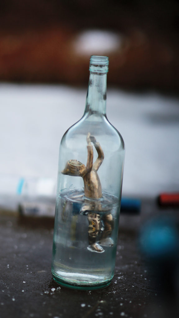 Jesse Tungilik, <em>Bottled</em>, 2018. Bronze-cast figure, clear polyester resin and bottle. Courtesy the artist.