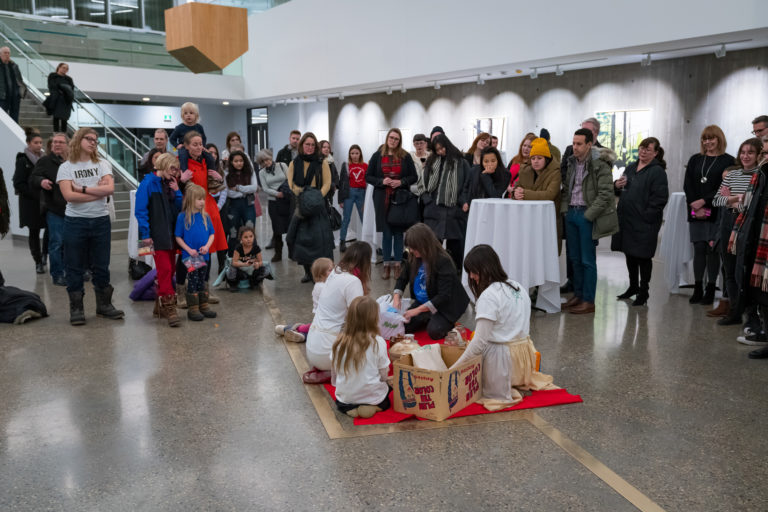 The Ephemerals perform <em>So Bey</em> (2019) as part of “Mothering Spaces” at the Mitchell Art Gallery. As part of the performance, the participants walked along a bronze line in the floor, part of a permanent installation outside the gallery by Brenda Draney. 