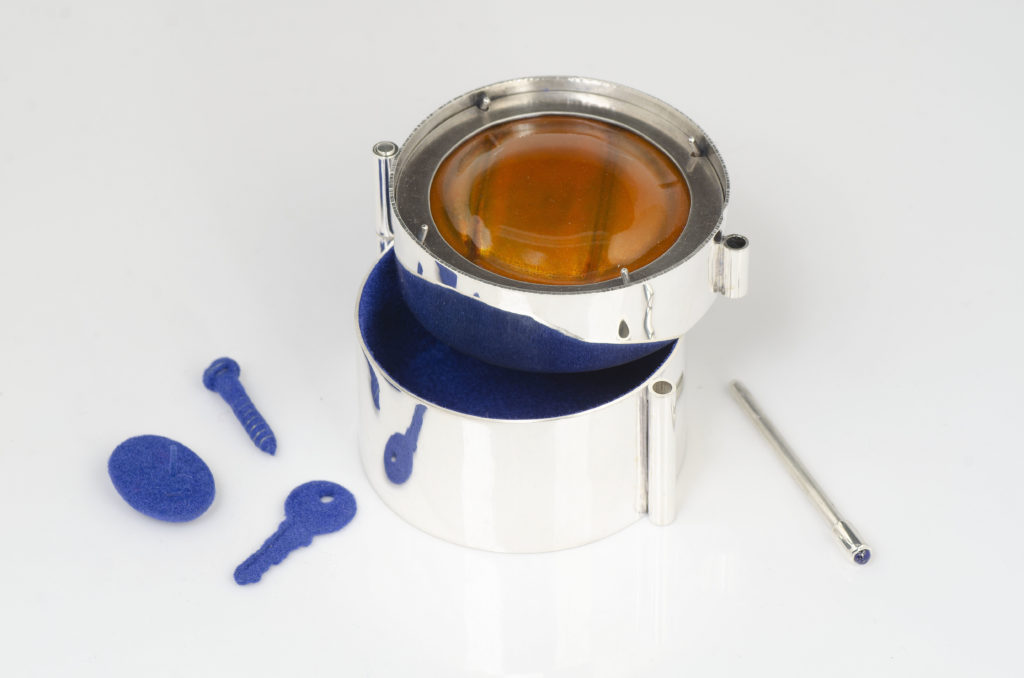 Kristyn Cooper, <em>Orange Curio Capsule</em>, 2018. Sterling silver, copper enamel, lapis lazuli, flocked found objects. Courtesy Beaverbrook Art Gallery. Photo: Drew Gilbert. 