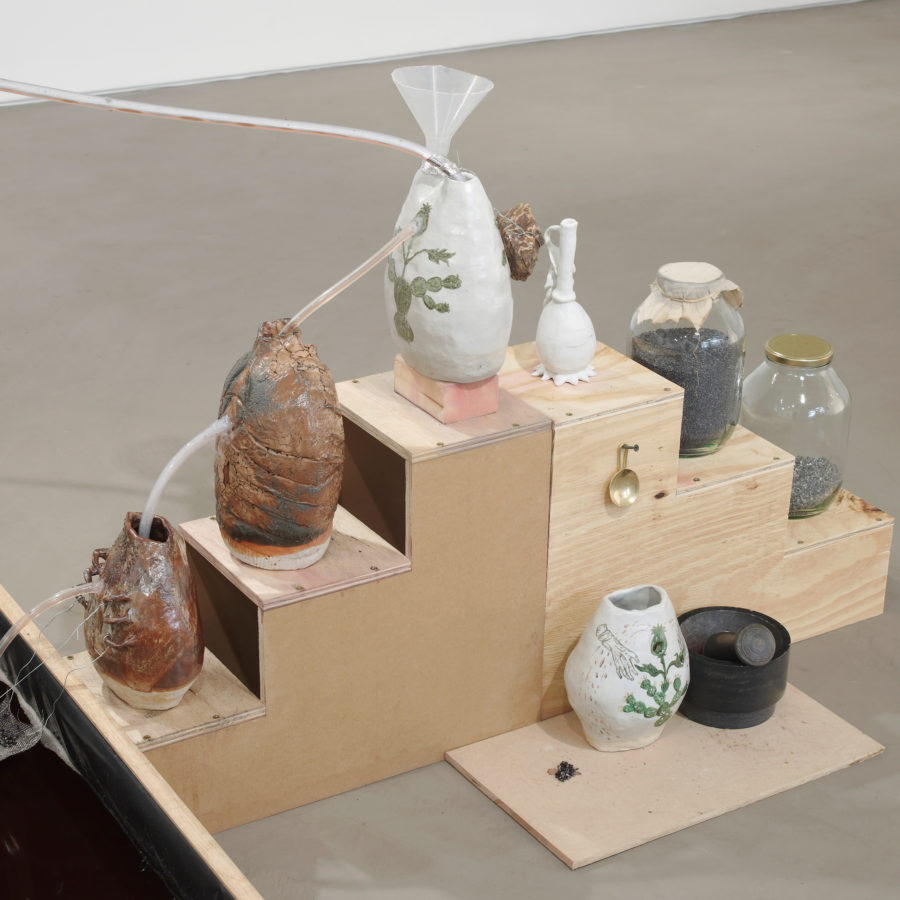 Candice Lin, <em>System for a Stain</em>, 2016. Wood, glass jars, cochineal, poppy seeds, metal castings, water, tea, sugar, copper still, hot plate, ceramic vessels, mortar and pestle, Thames mud, jar, microbial mud battery, vinyl floor. Dimensions variable. Commissioned by Gasworks. Courtesy the artist and François Ghebaly, Los Angeles. Photo: Andy Keate.