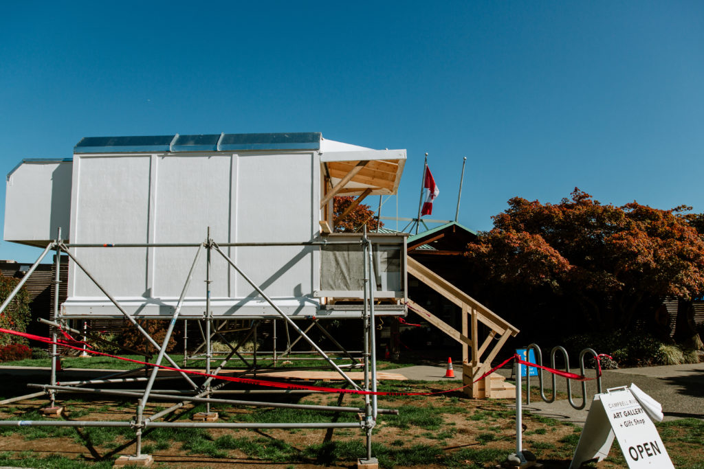 The crummy is a type of structure used to convey logging and resource workers to sites in BC. In <em>Crummy Gallery</em>, it was hoisted on scaffolding, a material that the Bomfords have often used in the past. Photo: Campbell River Art Gallery.