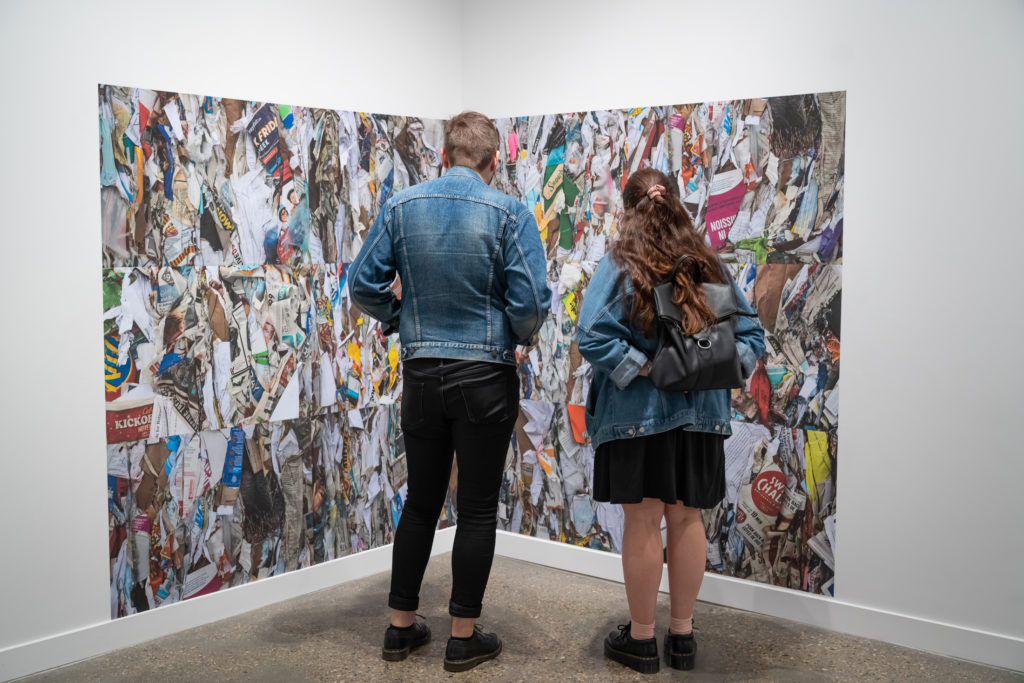 Visitors look at Leanne Olson’s photo-installation <em>Dream Life</em> (2018) during an opening reception at the Mitchell Art Gallery. Photo: Mitchell Art Gallery.