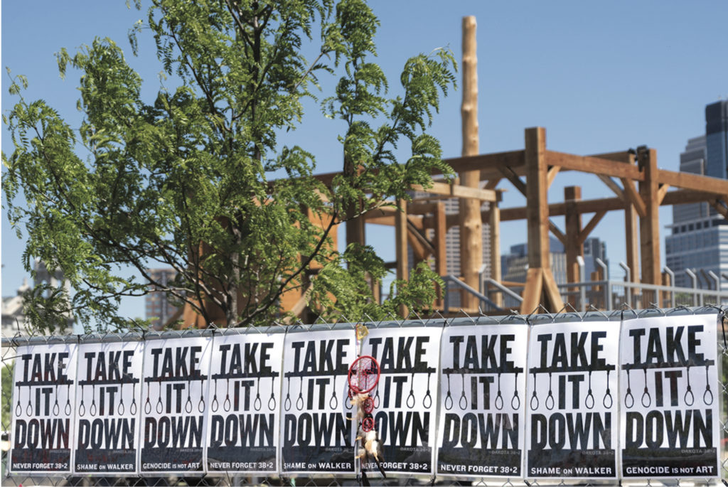 “Take It Down” signs protesting Sam Durant’s <em>Scaffold</em>, Minneapolis Sculpture Garden, 2017. Photo: Lorie Shaull/Flickr.