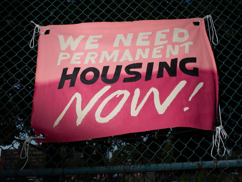 Jeff Bierk, <em>We Need Permanent Housing Now, with Simone Schmidt and Sarah Creskey, Alexander Park, August 13, 2020</em>, 2020. Photograph.