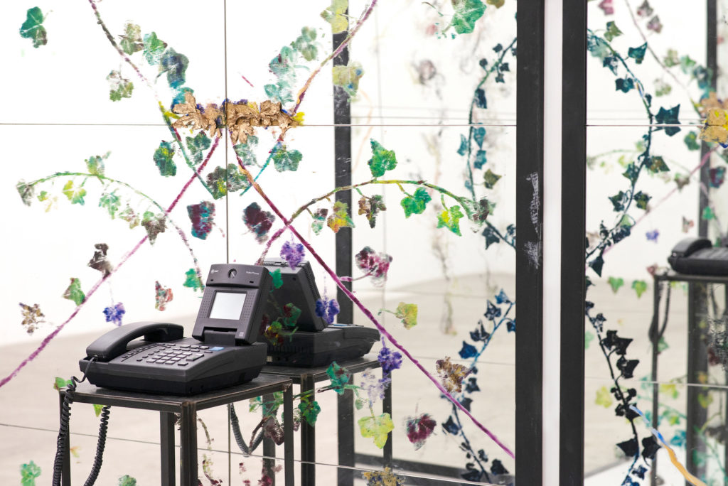 Chrysanne Stathacos, <em>1-900 Mirror Mirror</em>, detail, 1993–2020. Mirror, Plexiglas, wood, videophone, steel table, hand-printed hair, ivy and roses on mirror. Dimensions variable. Design consultant: Ken Saylor. Courtesy Cooper Cole, with The Breeder, Athens. 
